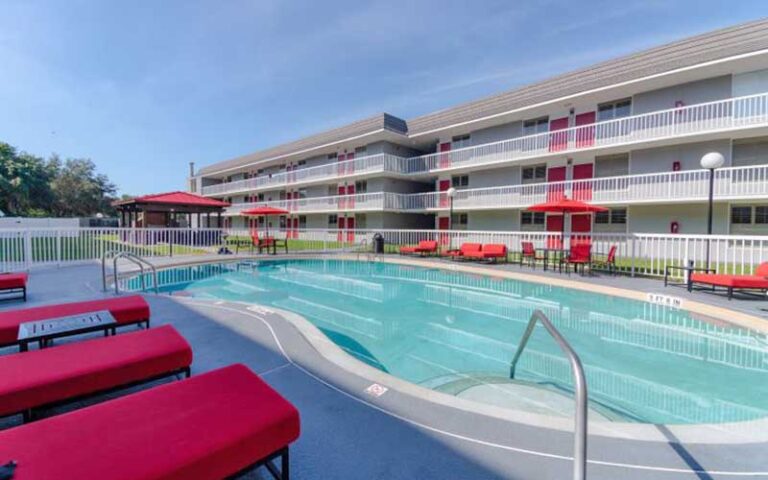 curvy pool with red seating and hotel at equus inn ocala