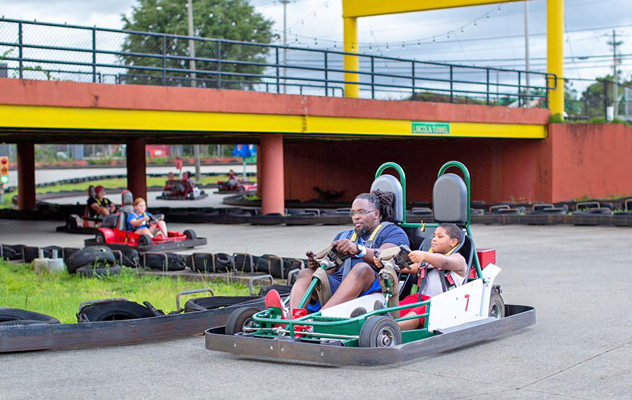 dad and son racing go kart on track with bridge at splash city adventures pensacola