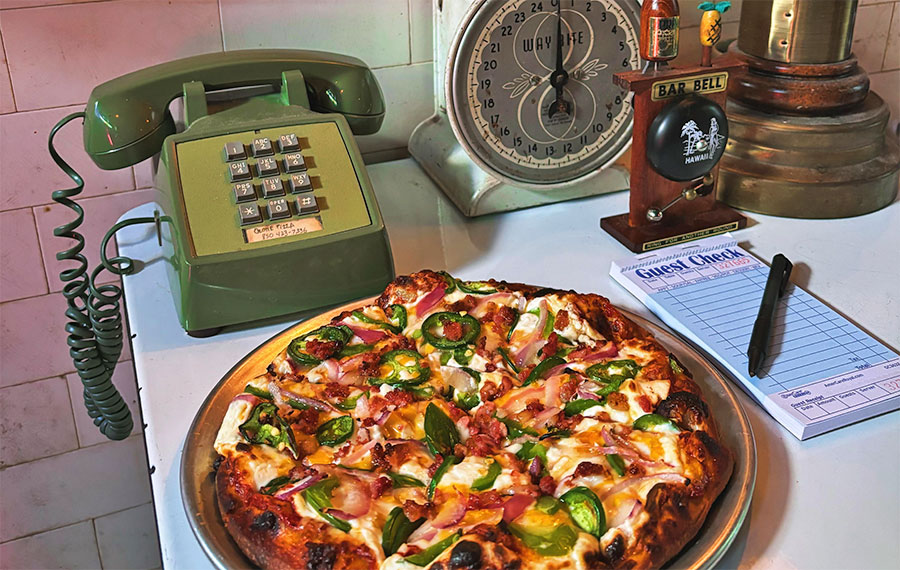 deluxe pizza set next to retro phone with delivery notepad at ozone pizza pub pensacola