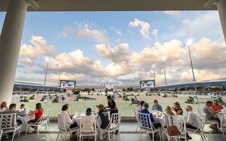 dining area under columns with server along edge of competition field at world equestrian center ocala