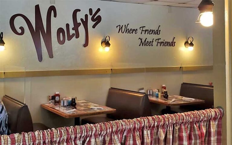 dining room interior with logo sign and booths at wolfys restaurant ocala