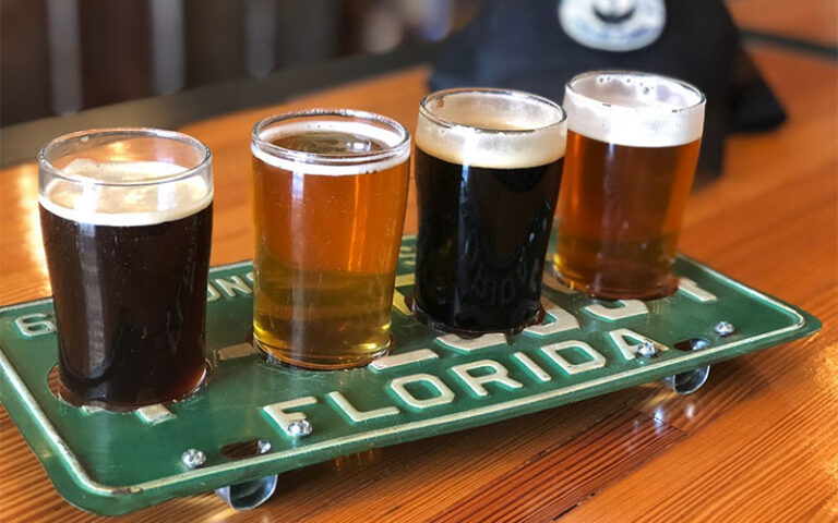 flight of beer varieties on license plate tray at swan brewing lakeland