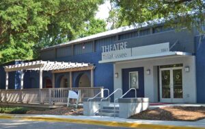 front exterior of blue building with sign and trees at theatre tallahassee