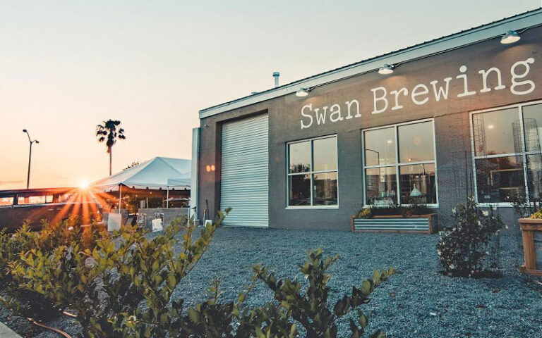 front exterior of brewery with patio and sunrise at swan brewing lakeland