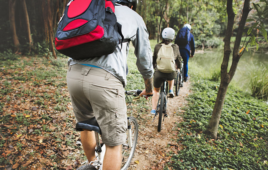 group of equipped bikers riding mountain bikes in wooded florida area