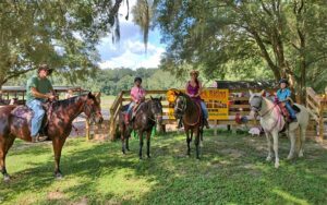 group of horseback riders with corral at cactus jacks trail rides ocala