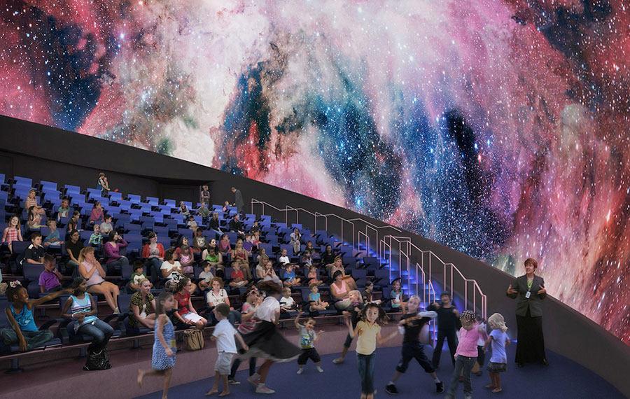 group of kids with guide in seating area of large theater with ceiling space image screen at frost planetarium miami