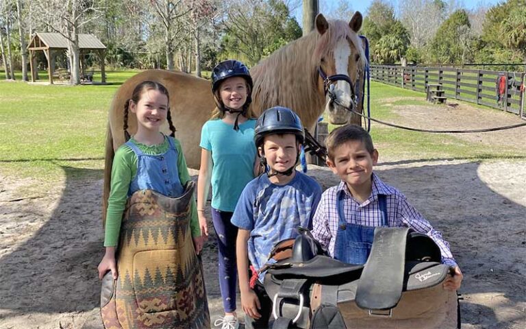 group of kids with saddle and horse in corral at hidden palms ranch sanford orlando