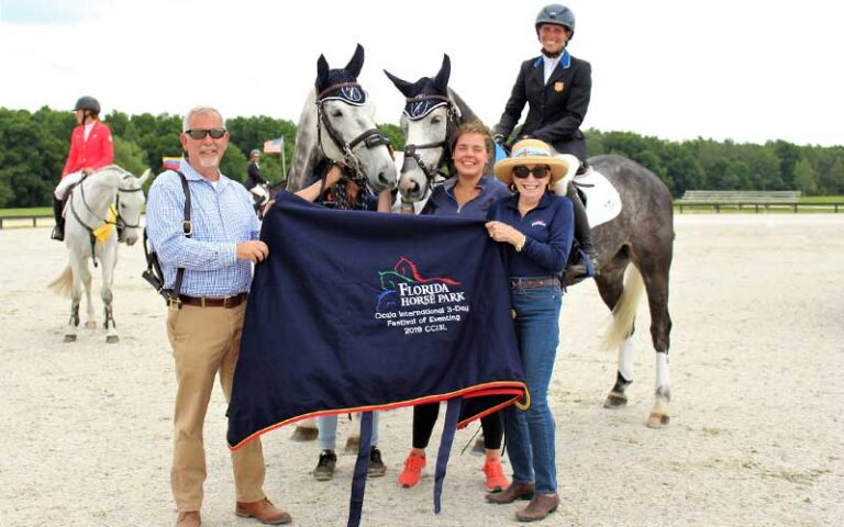 horses and team holding branded blanket at florida horse park ocala