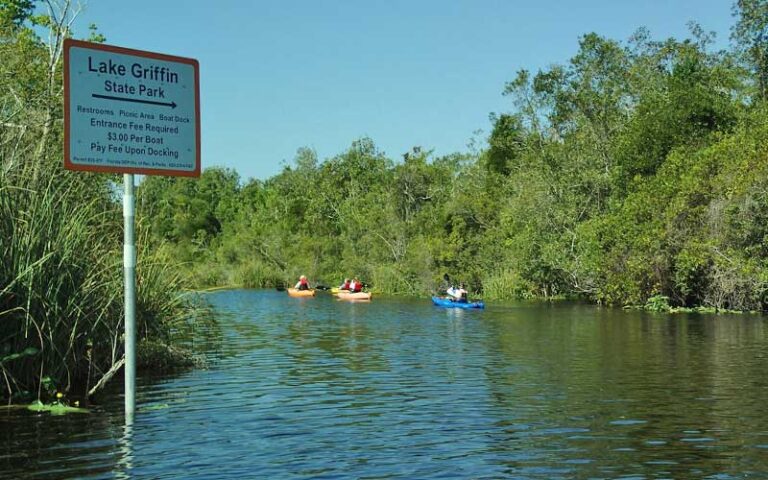 kayakers paddling along river with park sign at lake griffin state park fruitland ocala