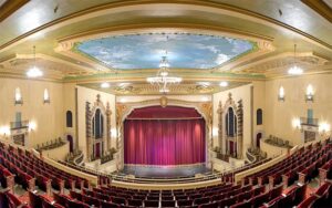 lighted stage theater with red curtains and rococo ceiling at saenger theatre pensacola