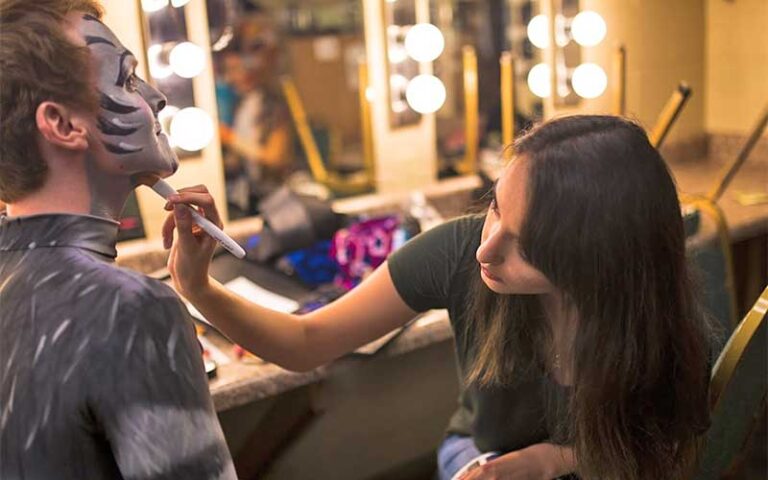 makeup artist backstage prepping cats actor at pensacola little theatre