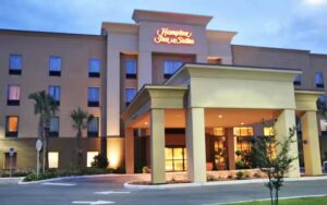 night exterior of high rise hotel with lighted entrance at hampton inn suites ocala belleview