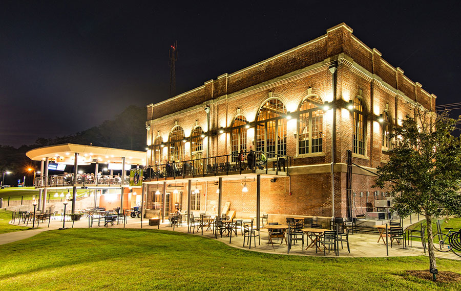 night exterior of lighted multi level brick building restaurant in park the edison tallahassee