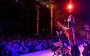 performer with guitar on stage with blue lighting and crowd at reilly arts center ocala