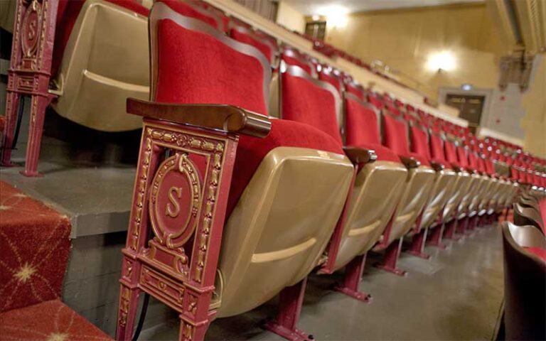 rows of gold and red cushioned seats in theater at saenger theatre pensacola