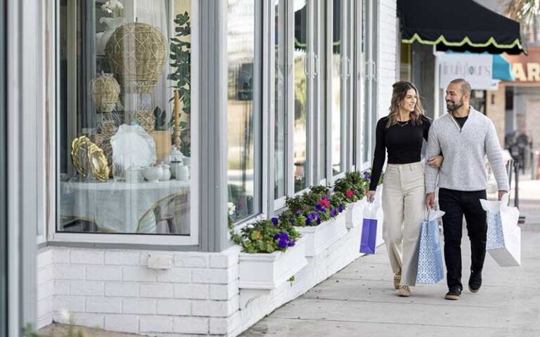 shopping couple walking along city sidewalk storefronts at historic downtown ocala