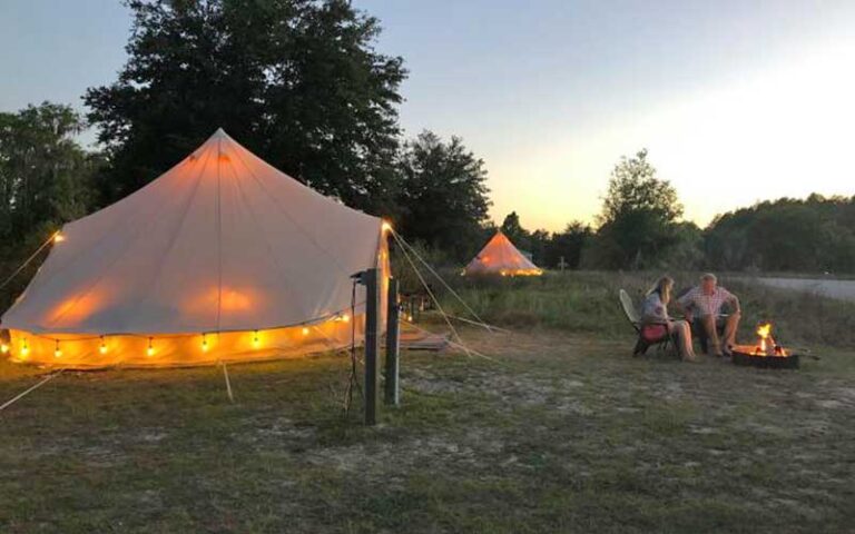 tent with lights and couple at campfire in twilight at lake louisa state park clermont orlando