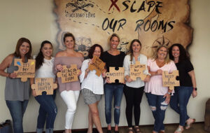 big group of ladies with signs at end of escape game at xscape our rooms st augustine