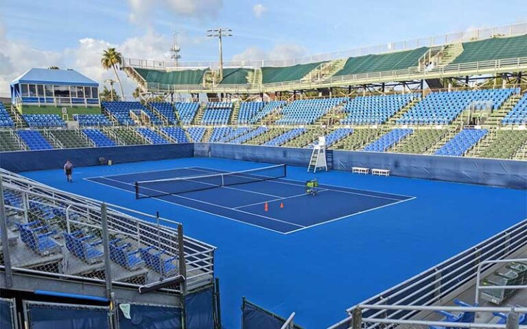 blue tennis court with stadium bleachers at delray beach tennis center