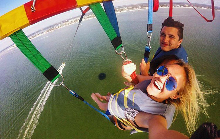 couple in parasail with aerial view of ocean paradise parasail fort myers beach