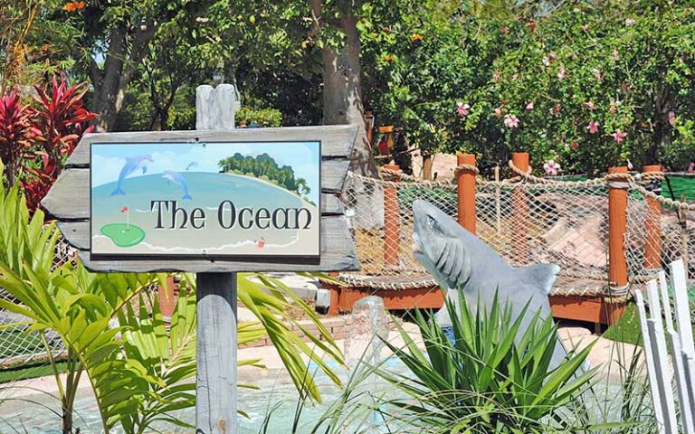 course sign ocean with shark statue and golf green at puttin around delray beach