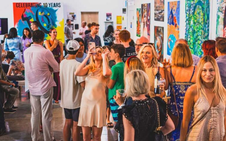 crowded art gallery with paintings at arts garage delray beach