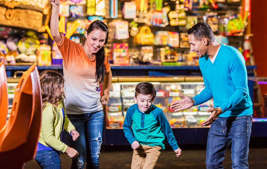 excited family running to arcade games with gallery background at adventure landing st augustine