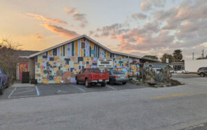 exterior at dusk of bar restaurant with mural and parking at sarbez st augustine