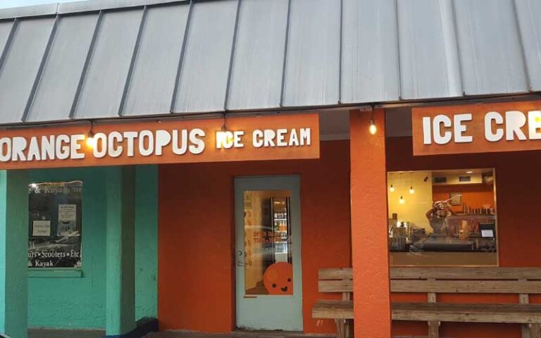 front exterior of shop with awning and window view of worker at orange octopus siesta key sarasota