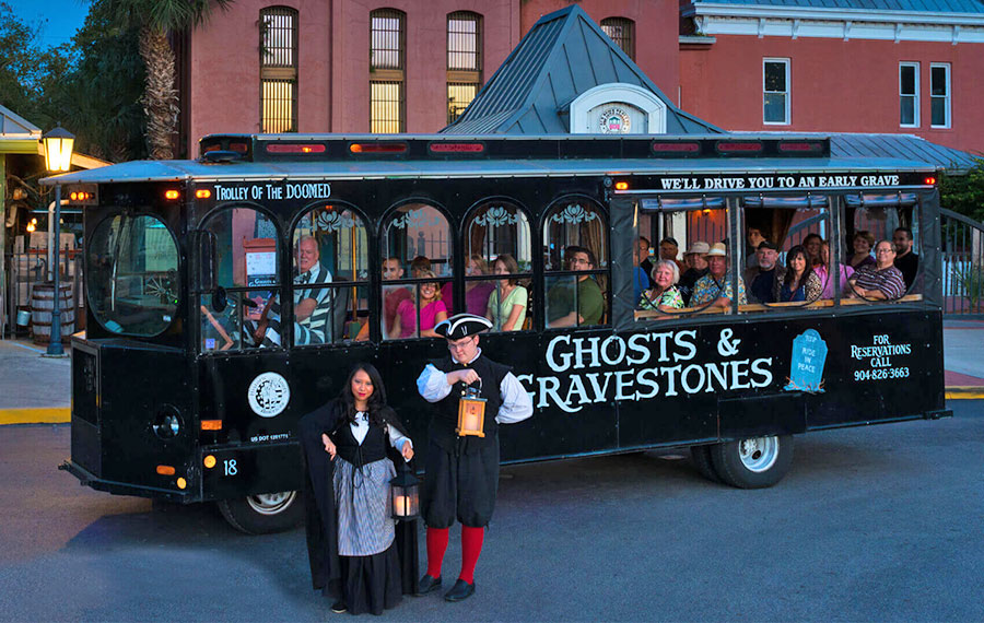 ghost tour trolley with costumed actors and riders parked at old town trolley tours st augustine