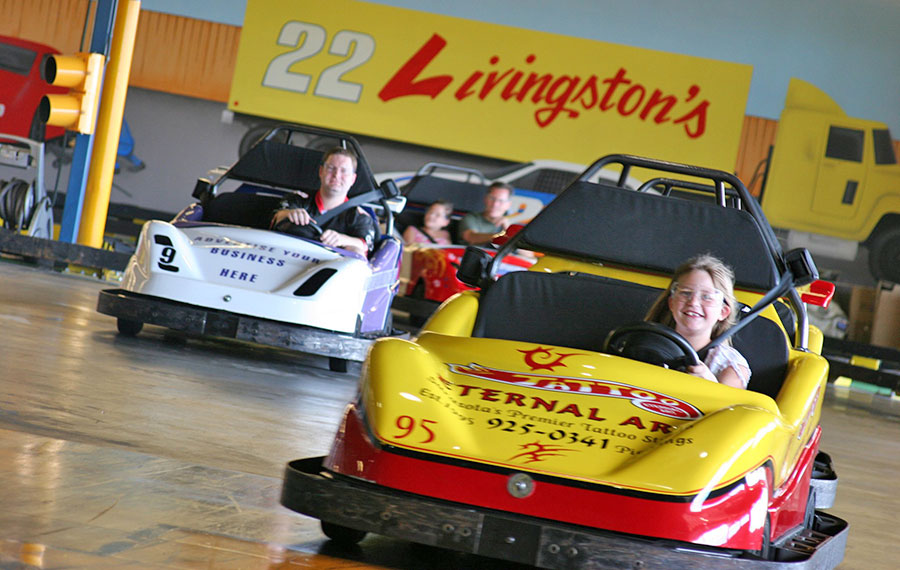 girl and man in car style karts racing along track livingstons amusements sarasota