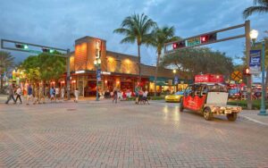 intersection with restaurants pedestrians and golf cart at twilight at east atlantic avenue delray beach