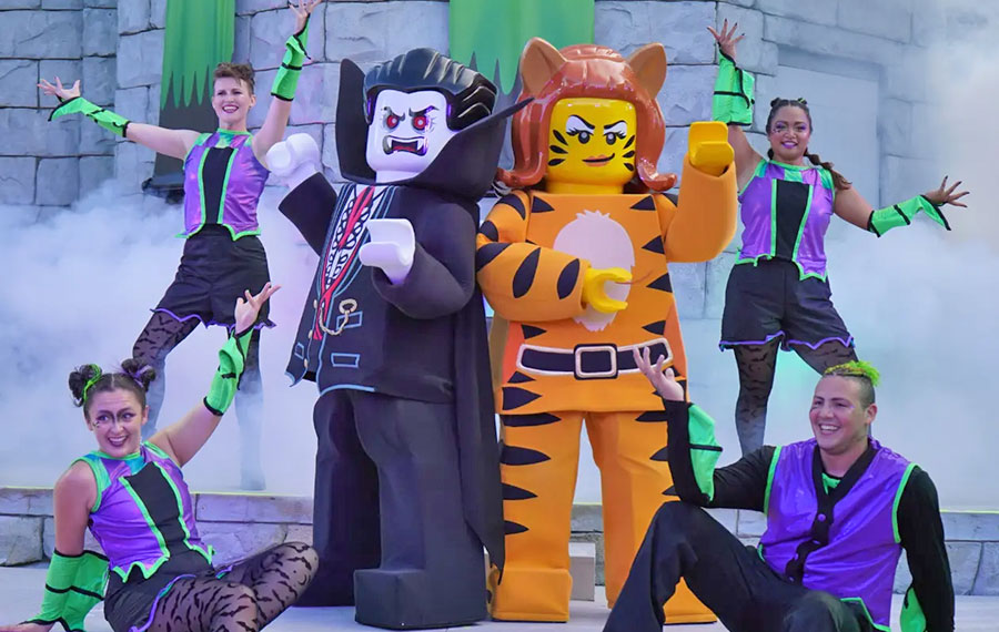 lego performers on outdoor stage with costumed monster characters at legoland florida resort