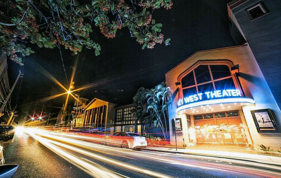 long exposure view of eaton street at night with traffic light trails and key west theater