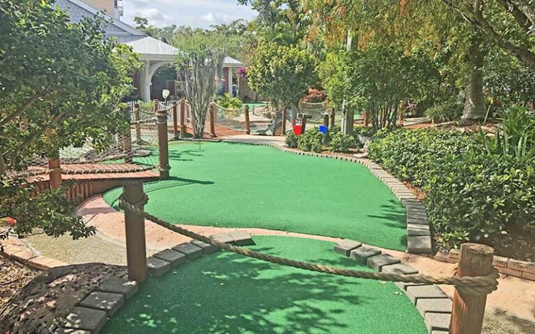 mini golf green with building at puttin around delray beach