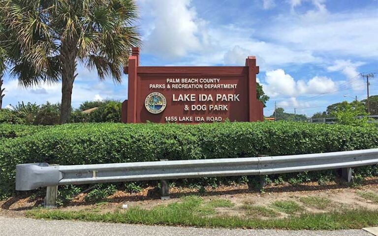 park sign behind hedge with guardrail at lake ida west park delray beach