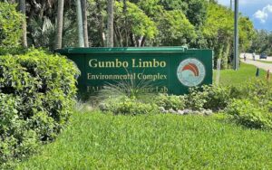 park sign from road with trees and bikers at gumbo limbo nature center boca raton