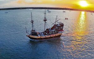 period pirate style galleon ship on bay with low sun at black raven pirate ship st augustine