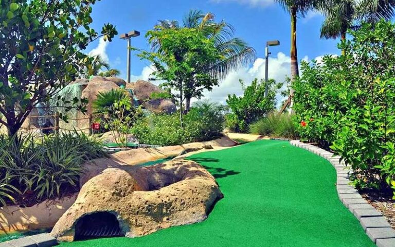 putting green with tropical plants and waterfall at puttin around delray beach