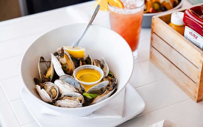 bowl of steamed clams and lemon with cocktail at bostons on the beach delray beach