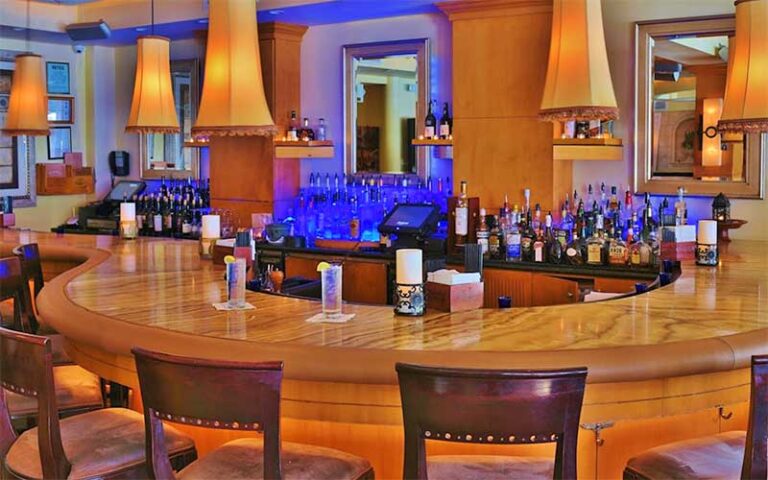 curving mahogany bar with lamp shade lighting at tramonti delray beach