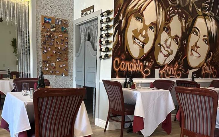 dining area with tables and artwork at le sorelle restaurant boca raton