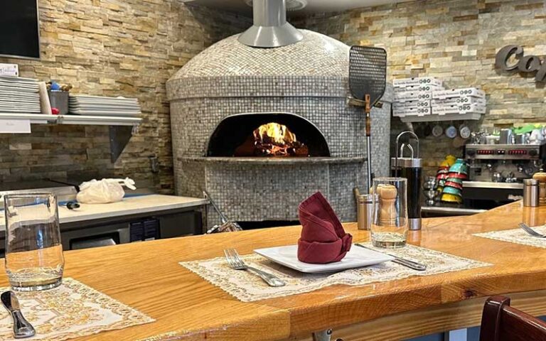 dining seating at bar with pizza oven at le sorelle restaurant boca raton