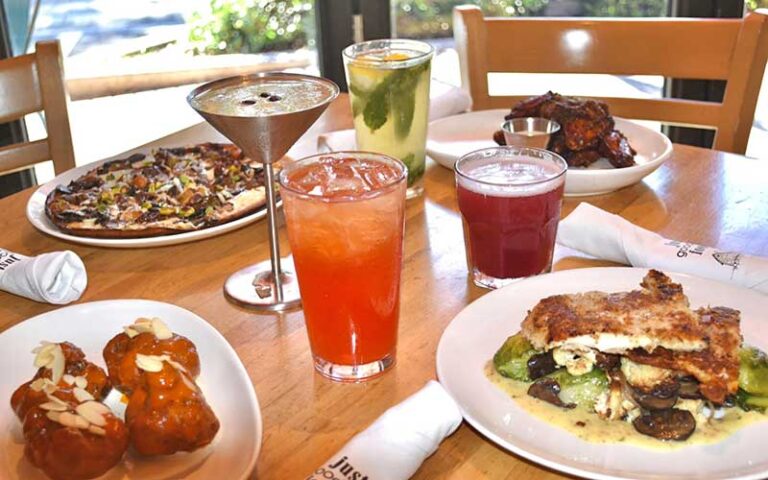 dining table spread with cocktails and entrees at gary racks farmhouse kitchen delray beach