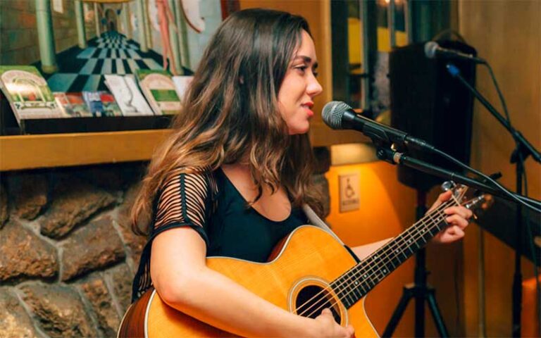 female performer with guitar and mic at dada delray beach