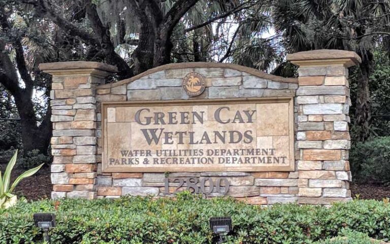 masonry park sign with trees and lights at green cay nature center wetlands boynton beach