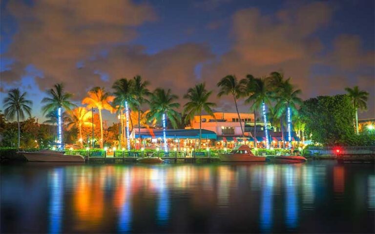 night view across inlet of colorfully lighted dockside restaurant at deck 84 delray beach