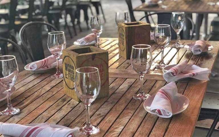 patio table setting with wine glasses at wood fire delray beach