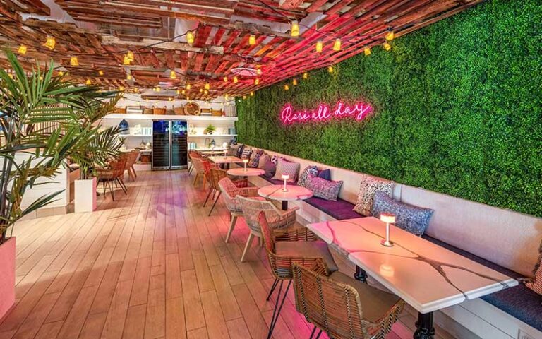 roomy dining space with wood ceiling and grassy wall at the hampton social delray beach